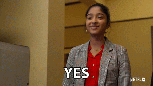 A Woman In A Plaid Jacket Is Smiling And Says Yes GIF
