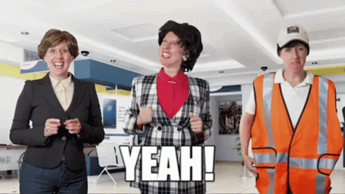 A Woman In A Plaid Jacket Is Standing Next To A Man In An Orange Vest Who Says Yeah GIF