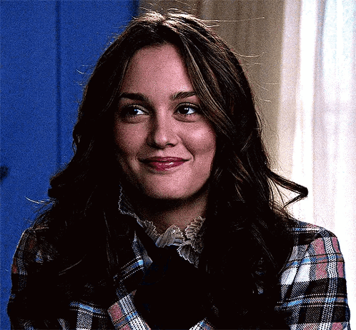 A Woman In A Plaid Shirt And Tie Is Smiling . GIF