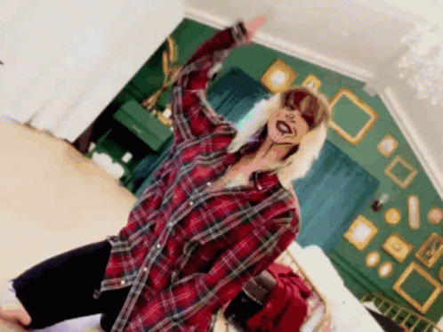 A Woman In A Plaid Shirt Is Kneeling On The Floor GIF