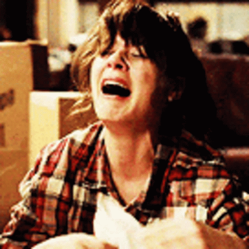 A Woman In A Plaid Shirt Is Laughing GIF