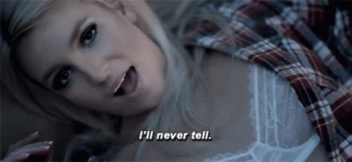 A Woman In A Plaid Shirt Is Laying Down And Says I 'Ll Never Tell GIF