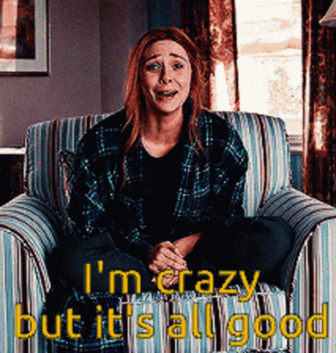 A Woman In A Plaid Shirt Is Sitting In A Chair With The Words " I 'M Crazy But It 'S All Good " GIF