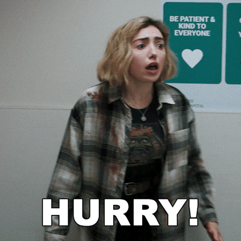 A Woman In A Plaid Shirt Is Standing In Front Of A Sign That Says Hurry GIF