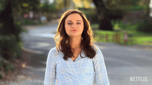 A Woman In A Plaid Shirt Is Walking Down A Street With Netflix Written On The Bottom Right GIF