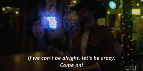 A Woman In A Plaid Shirt Stands In Front Of A Bar With A Neon Sign That Says Beer GIF