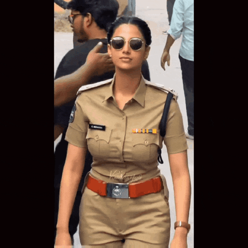 A Woman In A Police Uniform Has A Name Tag On Her Chest That Says ' S. Krishna ' GIF