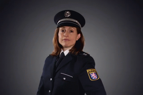 A Woman In A Police Uniform Is Pointing Her Finger GIF