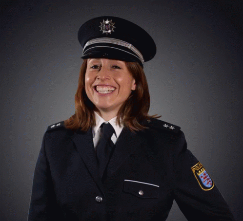 A Woman In A Police Uniform Is Smiling And Wearing A Badge That Says Police GIF
