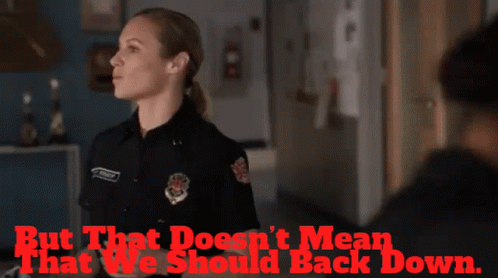 Police Woman Standing In Front Of Back Down Sign GIF
