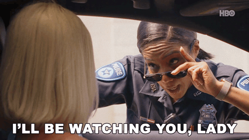 A Woman In A Police Uniform Says " I 'Ll Be Watching You Lady " While Wearing Sunglasses GIF