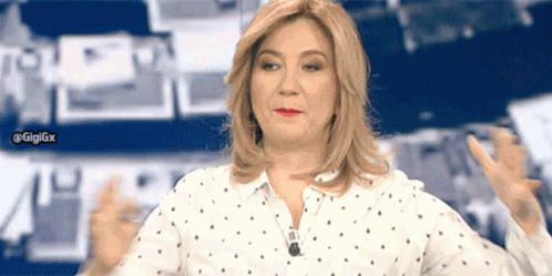 A Woman In A Polka Dot Shirt Is Giving A Thumbs Up Sign GIF