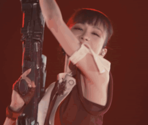 A Woman In A Ponytail Is Holding A Rifle GIF