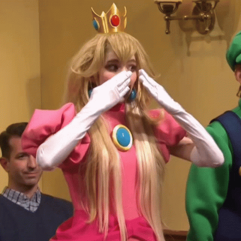 A Woman In A Princess Peach Costume Is Covering Her Mouth GIF