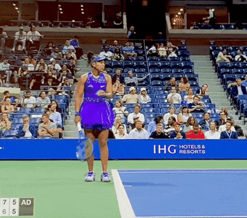 A Woman In A Purple Dress Is Holding A Tennis Racquet GIF