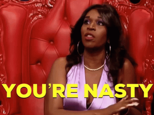A Woman In A Purple Dress Is Sitting In A Red Chair With The Words You 'Re Nasty In Yellow Letters Behind Her GIF