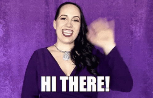 A Woman In A Purple Dress Is Smiling And Waving Her Hand With The Words Hi There . GIF