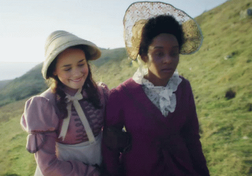 A Woman In A Purple Dress Is Walking With Another Woman GIF