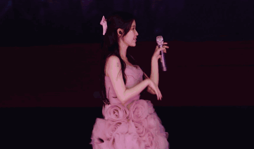 a woman in a purple dress sings into a microphone