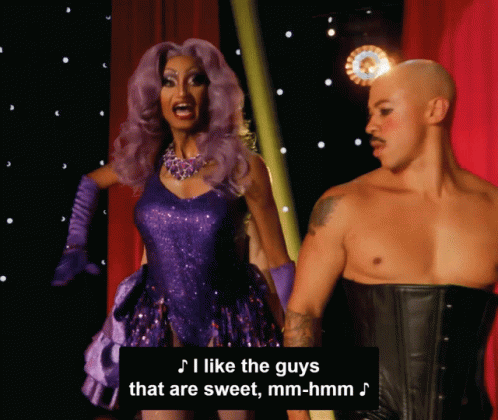 Woman In Purple Dress Next To Man In Black Corset GIF