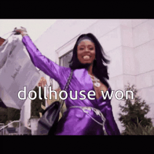 A Woman In A Purple Dress With The Words Dollhouse Won Written Above Her GIF