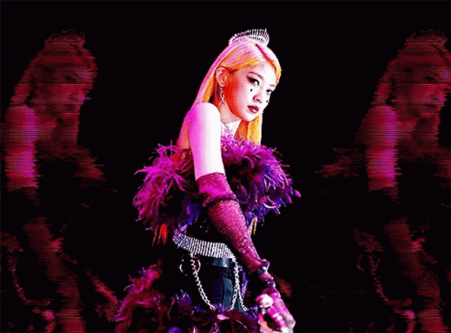A Woman In A Purple Feathered Dress Is Holding A Sword In Her Hand . GIF