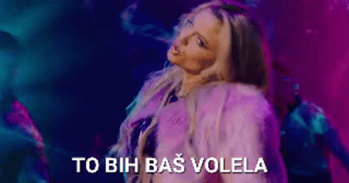 A Woman In A Purple Fur Coat Is Dancing In Front Of A Purple And Blue Background . GIF