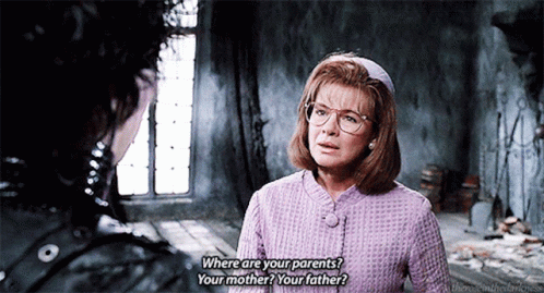 A Woman In A Purple Jacket Is Talking To A Man In A Room And Asking Where Are Your Parents GIF