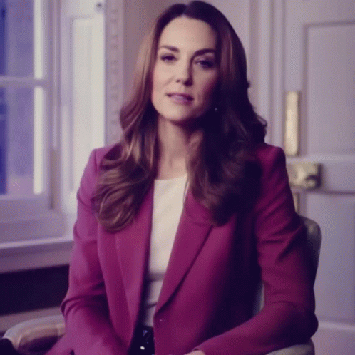 A Woman In A Purple Jacket Sits In A Chair GIF