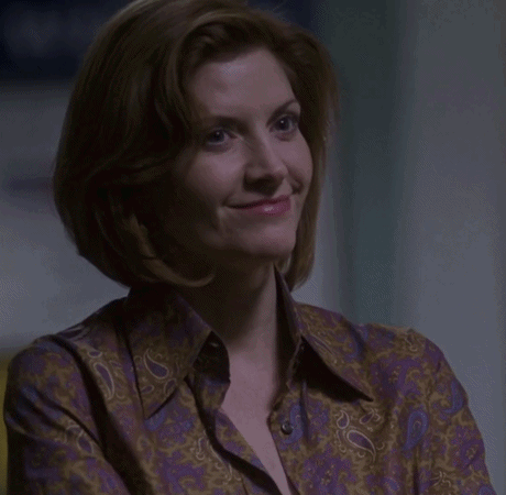 a woman in a purple paisley shirt is smiling