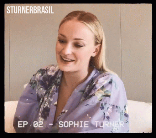 A Woman In A Purple Robe Is Smiling In A Video From Sturner Brasil GIF