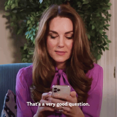 A Woman In A Purple Shirt Is Looking At Her Cell Phone And Says That 'S A Very Good Question GIF