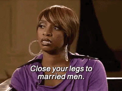 A Woman In A Purple Shirt Is Sitting On A Couch And Talking To A Married Man . GIF