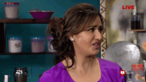 A Woman In A Purple Shirt Is Standing In Front Of A Live Sign GIF