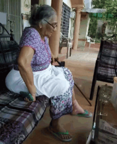 A Woman In A Purple Shirt Sits On A Bench GIF