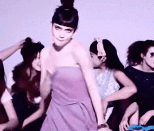 A Woman In A Purple Strapless Dress Is Dancing With Other Women GIF