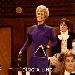 A Woman In A Purple Suit Is Holding A Triangle In Front Of A Crowd . GIF
