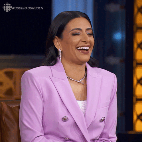 A Woman In A Purple Suit Is Laughing With The Hashtag #Cbcdragonsden Above Her GIF