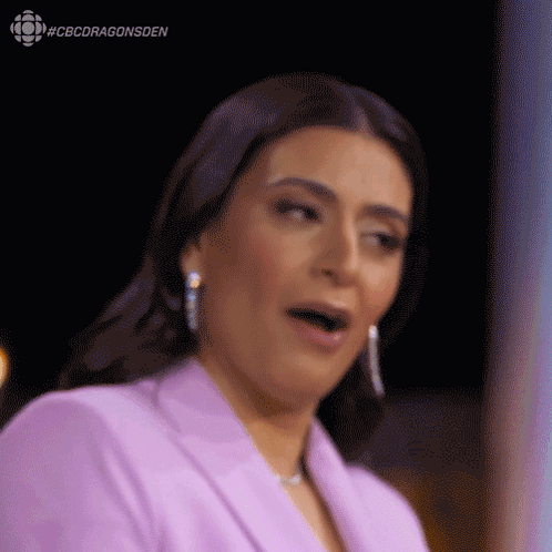 A Woman In A Purple Suit Is Making A Funny Face . GIF