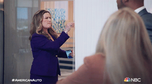 Woman In Purple Suit Taking Photo With NBC Logo GIF