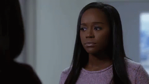 A Woman In A Purple Sweater Is Talking To Another Woman In A Room . GIF
