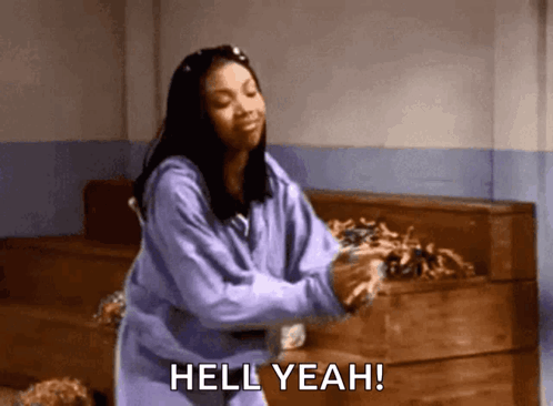 A Woman In A Purple Sweatshirt Is Dancing And Saying Hell Yeah ! GIF