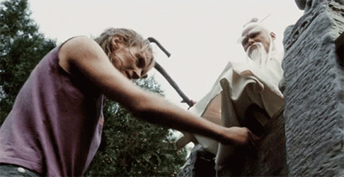 A Woman In A Purple Tank Top Is Reaching Out Towards A Statue GIF