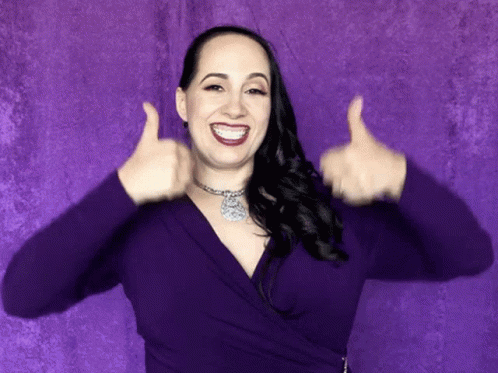 A Woman In A Purple Top Is Giving Two Thumbs Up GIF