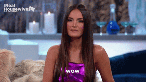 A Woman In A Purple Top With Wow Written On It GIF