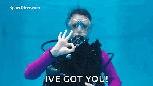 A Woman In A Purple Wetsuit Is Holding A Starfish In Her Hand Underwater . GIF
