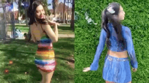 A Woman In A Rainbow Dress And A Blue Skirt Is Standing In A Park . GIF