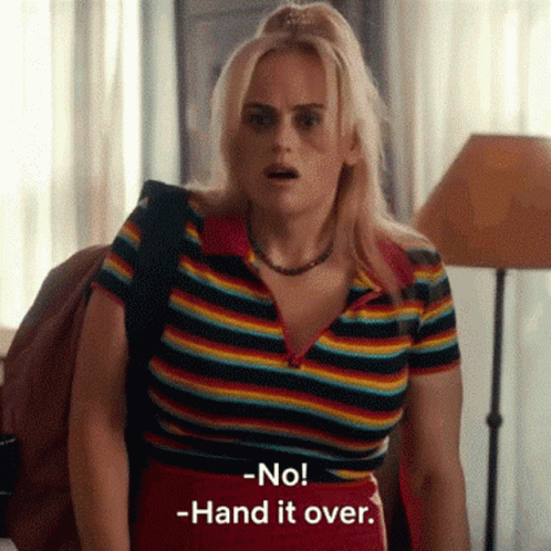 A Woman In A Rainbow Striped Shirt Is Standing In A Room . GIF