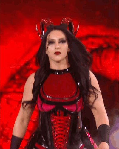 A Woman In A Red And Black Costume Is Dancing GIF