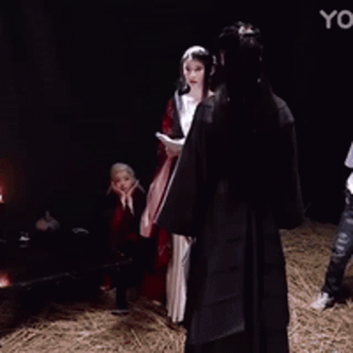 A Woman In A Red And Black Dress Is Making A Funny Face With Her Hands On Her Face . GIF